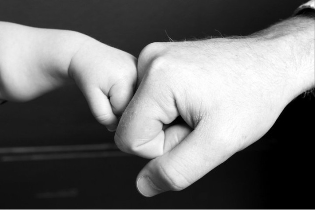 father and son fist bump